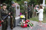 Wojewoda Agata Wojtyszek składa kwiaty przed pomnikiem z popiersiem księdza Romana Kotlarza. 